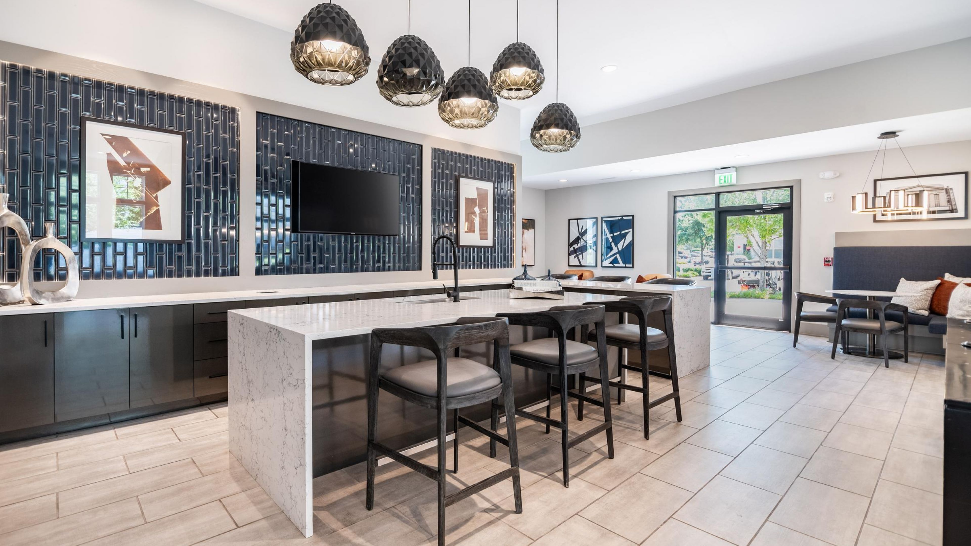 Hawthorne Davis Park apartment social kitchen area with modern bar style seating and a tv mounted on the wall
