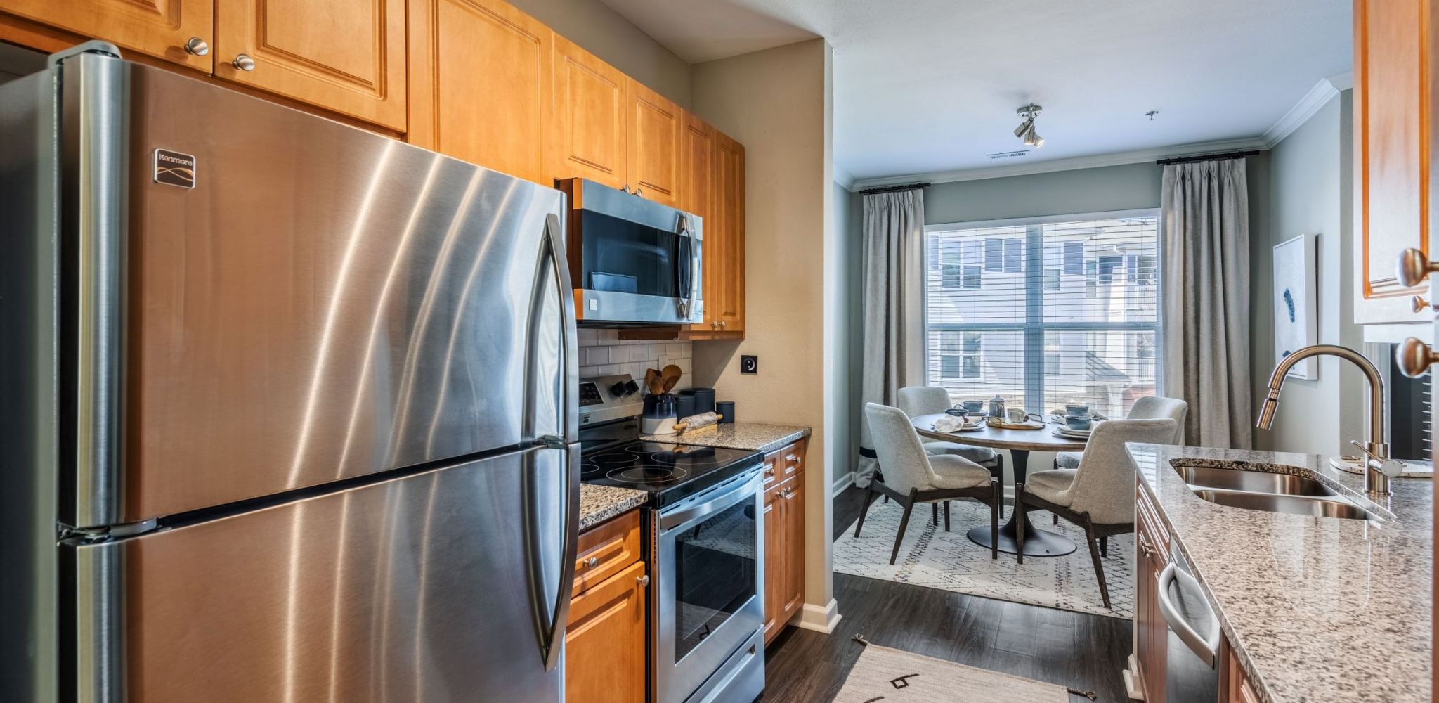 Hawthorne Davis Park apartment kitchen and dining space with wood floor and stainless steel appliances